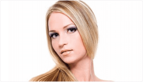 Uma mulher com longos cabelos loiros e olhos azuis utilizando os produtos para platinar da dot cosmeticos
